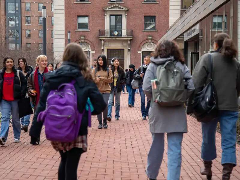 students walking on campus in front of milstein